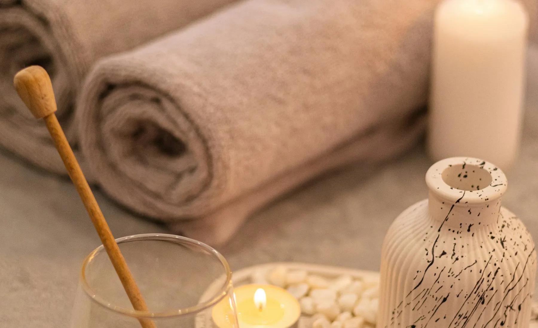 Warm, dimly lit massage room with folded towels and candlelight