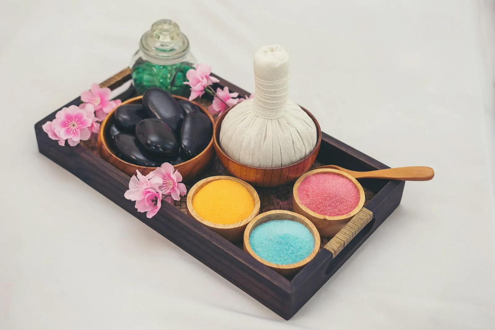 Welcome tray with hot stones, a herbal compress and bath salts
